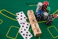 wooden dice on which writes poker playing cards and chips laid out on a poker table Royalty Free Stock Photo