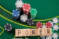 wooden dice on which writes poker playing cards and chips laid out on a poker table Royalty Free Stock Photo