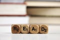 Wooden dice with the words Read with blurred books