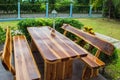 A wooden dining table set in lush garden setting Royalty Free Stock Photo