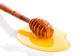 Wooden dipper in liquid honey close-up on white background