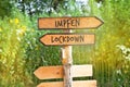 Wooden direction sign with the German word impfen vaccinate and Lockdown Royalty Free Stock Photo