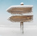 Wooden direction sign with snow and snowfall bg. two_arrows-one_direction Royalty Free Stock Photo