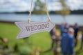 Wooden direction with wedding text is hanging near location of the ceremony, selective focus Royalty Free Stock Photo