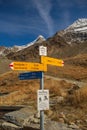 Wooden directional signpost with arrows pointing in multiple directions in the Swiss Alps
