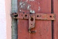 Wooden dirty red blank aged door for backdrop with rusty latch - closeup