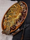 Wooden dish with grilled seafish. Seafood with vegetables on a dark wooden table. Seatrout. Two authentic forks. Delicious and