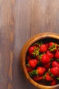 wooden dish with strawberries. wood background, top view