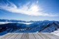 Wooden display shelf table top against blurred snow covered winter mountain panorama on a sunny day, blue sky Royalty Free Stock Photo