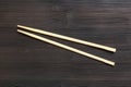 Wooden disposable chopsticks on dark brown table