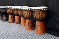 Wooden djembe drums in a row on the floor.