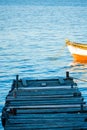 Wooden dock and the boat on the sea. Seagull, dock, and boat on the calm water landscape view.