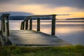 Wooden dock extends out into the tranquil lake at sunset Royalty Free Stock Photo