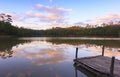 Wooden dock on serene lake with sunset Royalty Free Stock Photo