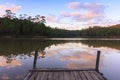 Wooden dock on serene lake with sunset Royalty Free Stock Photo