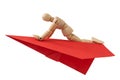 Wooden doll flying on a paper plane Royalty Free Stock Photo