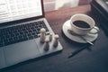 The wooden doll represents the employee of the company in workplace and document budget, calculator and coffee cup on the table.