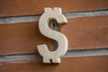 Wooden dollar symbol on brick wall background