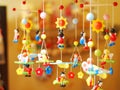 Wooden dolls, painted in various colors, strung on strings for festival decorations.