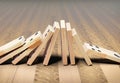 Wooden domino stones pyramid on wood floor falling over chain reaction