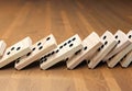 Wooden domino stones pyramid on wood floor falling over chain reaction