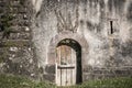 Wooden door on an antique wall made of stones and cement Royalty Free Stock Photo