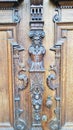 Wooden door, carved figure in the middle. The door is dark brown.