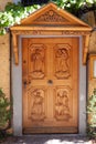 Wooden door with carvings of people depicting winemakers