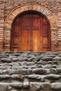 Wooden door with a cross carved in the middle at the entry of an old church in Colombia Royalty Free Stock Photo