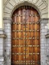 A wooden door with gray limestone and metal decorations