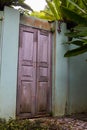 Wooden door without house. Door in a wall or fence overgrown by green lush tropical vegetation. A front door instead of a garden Royalty Free Stock Photo