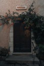 Wooden door leading to an abandoned building covered in lush vegetation