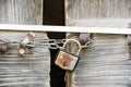 A wooden door locked with a chain and a rusty padlock Royalty Free Stock Photo