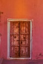 Antique indian wooden door on a pink wall