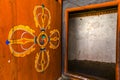 Wooden door with painted Buddhist symbols in Trongsa Dzong monastery in Trongsa, Bhutan