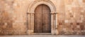 A wooden door set within a stone arch on the building facade Royalty Free Stock Photo