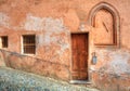 Wooden door and small paved street in Saluzzo.