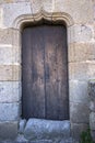 Wooden door with stone Mudejar arch bell tower of Santa Maria church in Hervas vertical Royalty Free Stock Photo