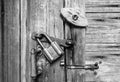 Wooden door surface with handle, old padlock, old metal and wooden latches.Black and white texture Royalty Free Stock Photo