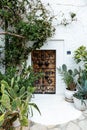 Wooden door to a traditional white house situated in a vibrant garden of green foliage in Tunisia Royalty Free Stock Photo