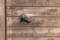 Wooden door with vintage metal handle. The door surface is made of wooden horizontal slats with a worn texture and scratches Royalty Free Stock Photo