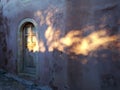 Wooden door and wall of a house illuminated by the rising sun, Monemvasia, Greece