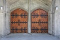 Wooden door way. Double wooden doors with ornamental iron design