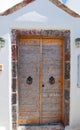 Wooden door from whitewashed house carved into the rock in Fira town on the island of Thira (Santorini), Greece. Royalty Free Stock Photo