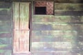 Wooden door and window of green wooden cottage.