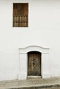 Wooden door and window in white colonial wall