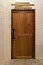 Wooden door with wood nameplate on the top in dark empty room.