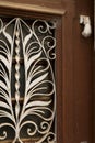 Wooden door with wrought iron details and doorknocker hand shaped