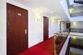 Wooden doors, red carpet on floor and handrails of balconies