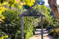 A wooden doorway with a dirt path to the discovery garden surrounded by lush green plants and trees Royalty Free Stock Photo